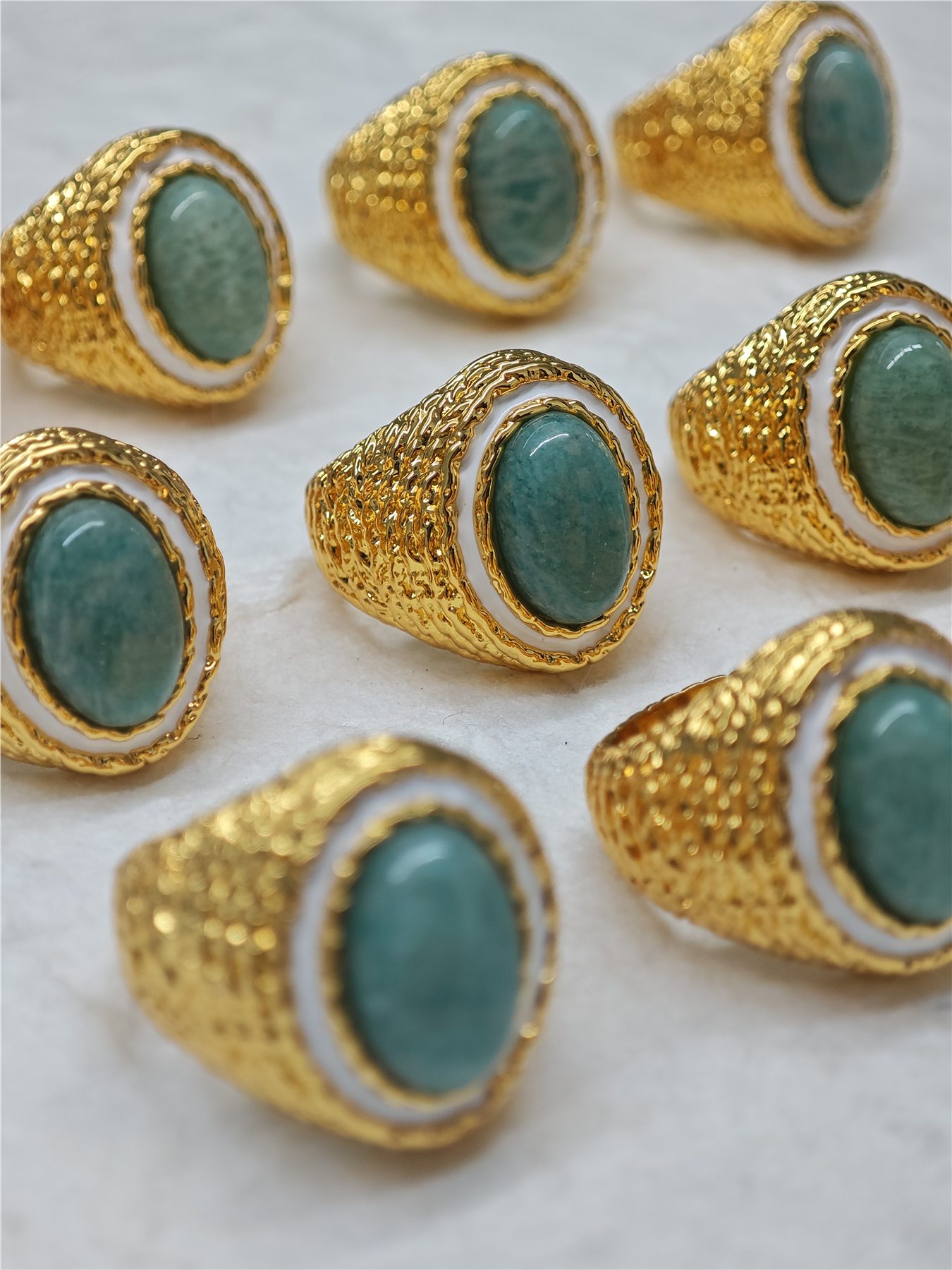 Batch of gold-color textured rings with green stones