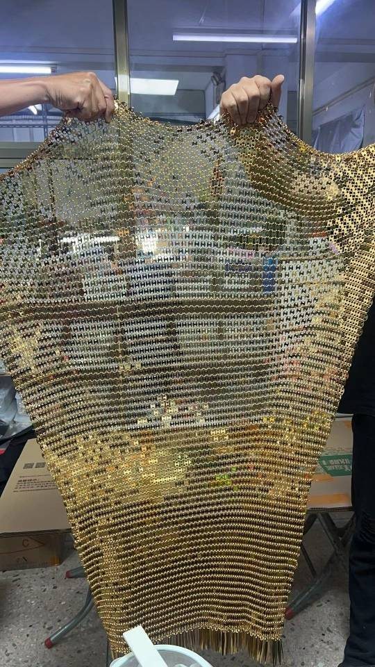 Workshop assembly of a gold-color metal mesh fashion piece