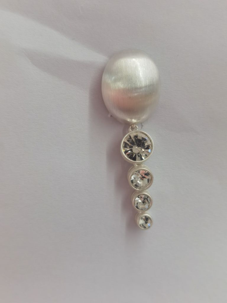 Physical component sample with graduated clear stones below a rounded top element